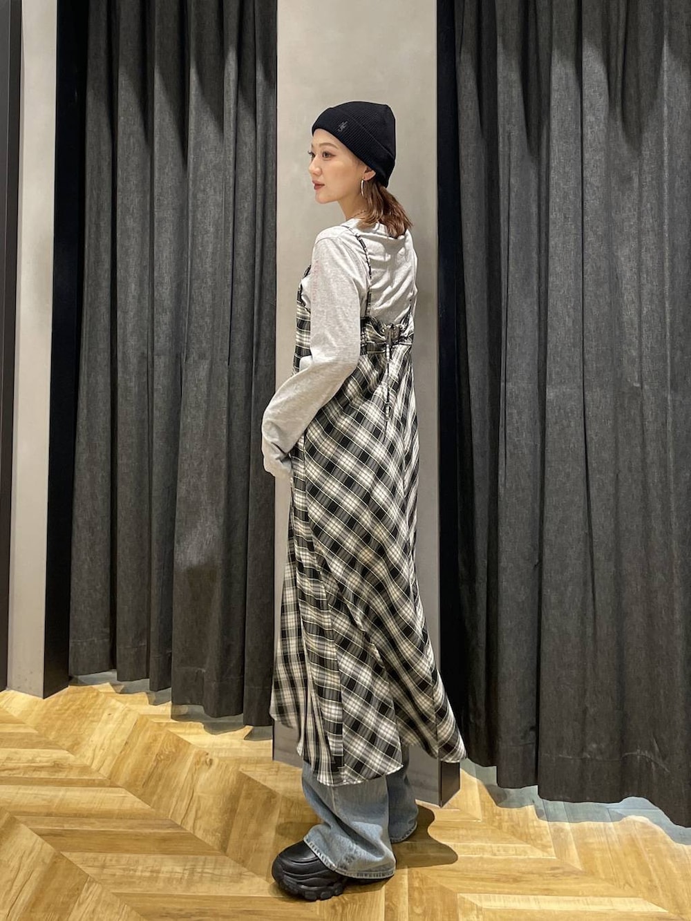 ブラック系のローファー、ブルー系のデニムパンツ、ブラック系のワンピースを着用したレディースの春コーディネートの3枚目の写真