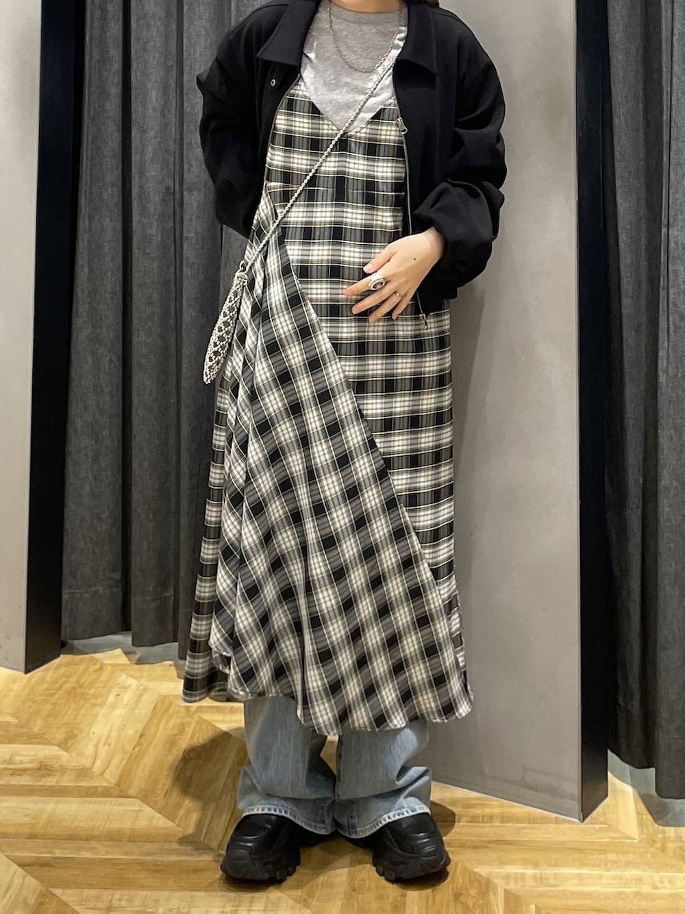 ブラック系のローファー、ブルー系のデニムパンツ、ブラック系のワンピースを着用したレディースの春コーディネートの4枚目の写真