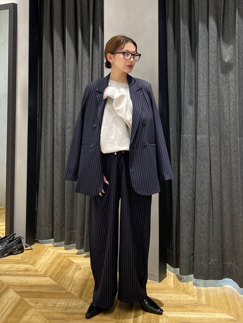 ブラック系のローファー、グレー系のスウェット、ブルー系のスラックスを着用したレディースの冬コーディネートの4枚目の写真