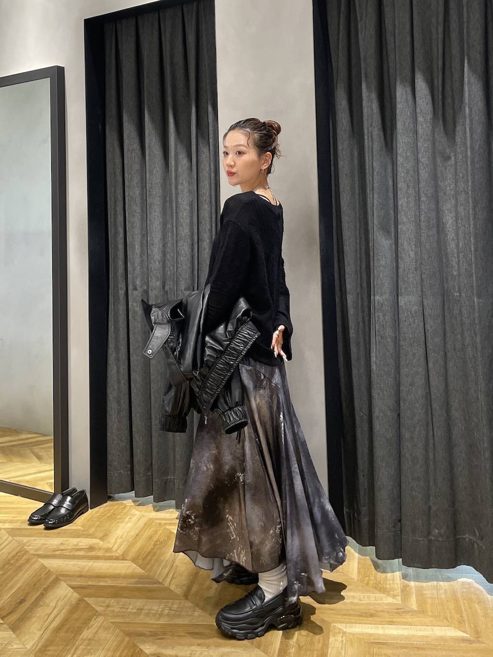 ブラック系のローファー、ブラック系のブルゾン、シルバー系のスカートを着用したレディースの冬コーディネートの5枚目の写真