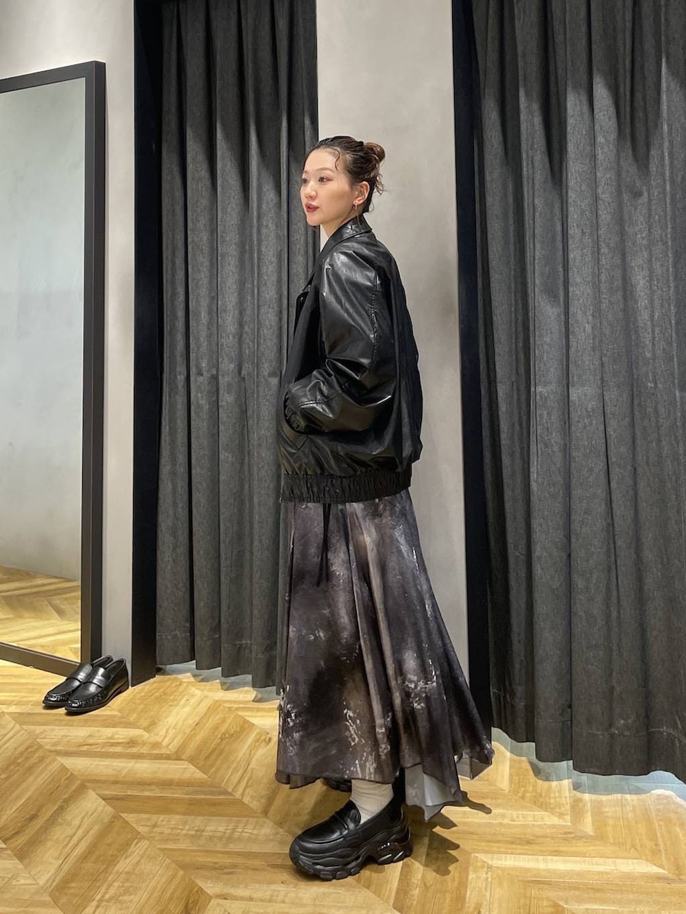 ブラック系のローファー、ブラック系のブルゾン、シルバー系のスカートを着用したレディースの冬コーディネートの3枚目の写真