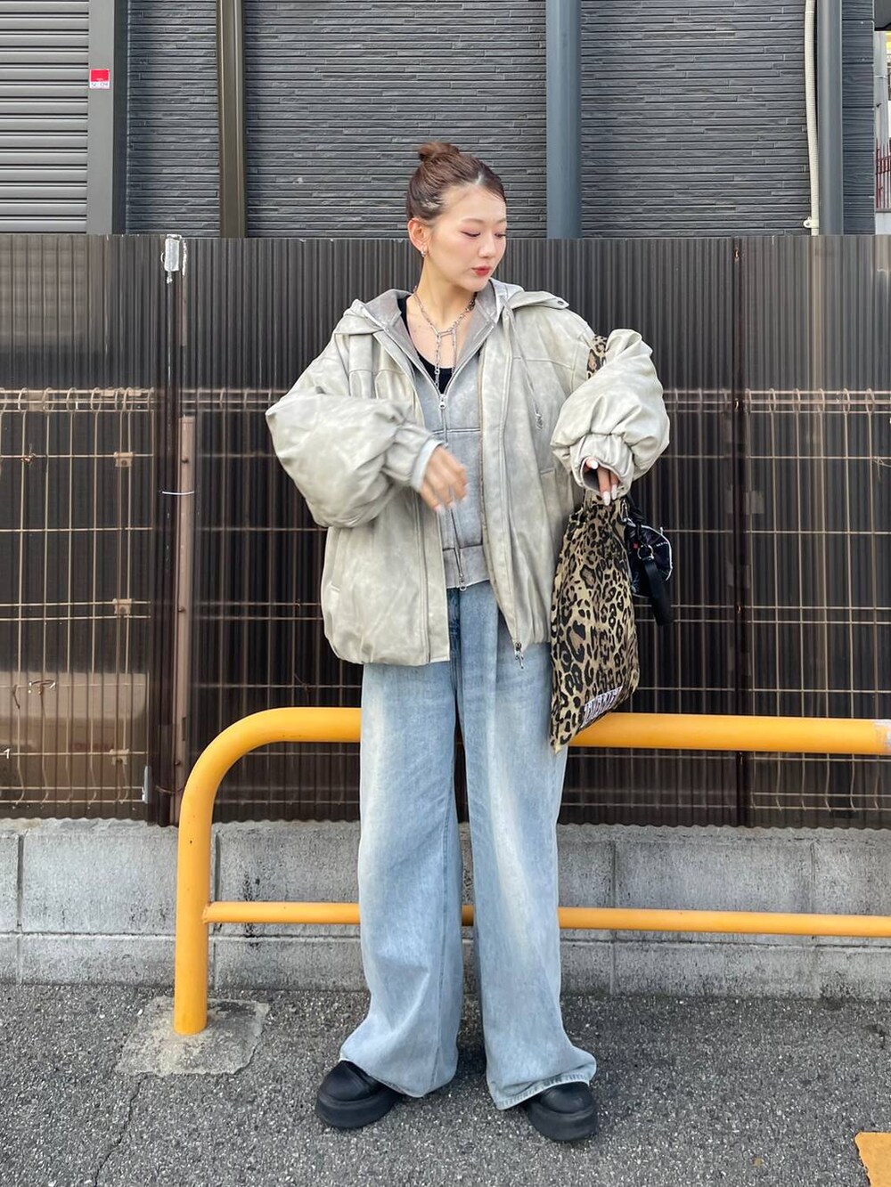ベージュ系のブルゾン、グレー系のパーカー、ブルー系のデニムパンツを着用したレディースの冬コーディネートの2枚目の写真
