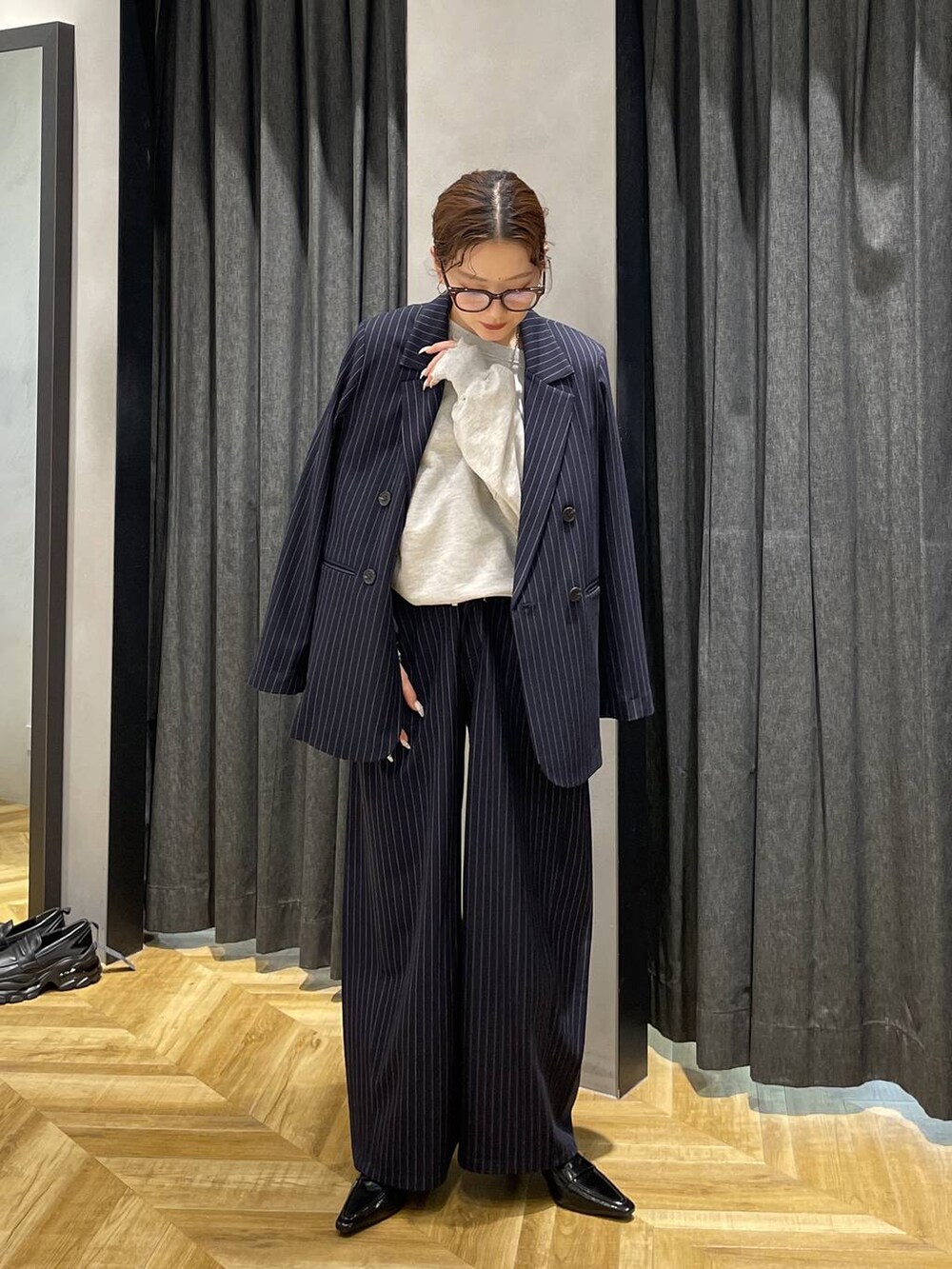 ブラック系のローファー、グレー系のスウェット、ブルー系のスラックスを着用したレディースの冬コーディネートの3枚目の写真