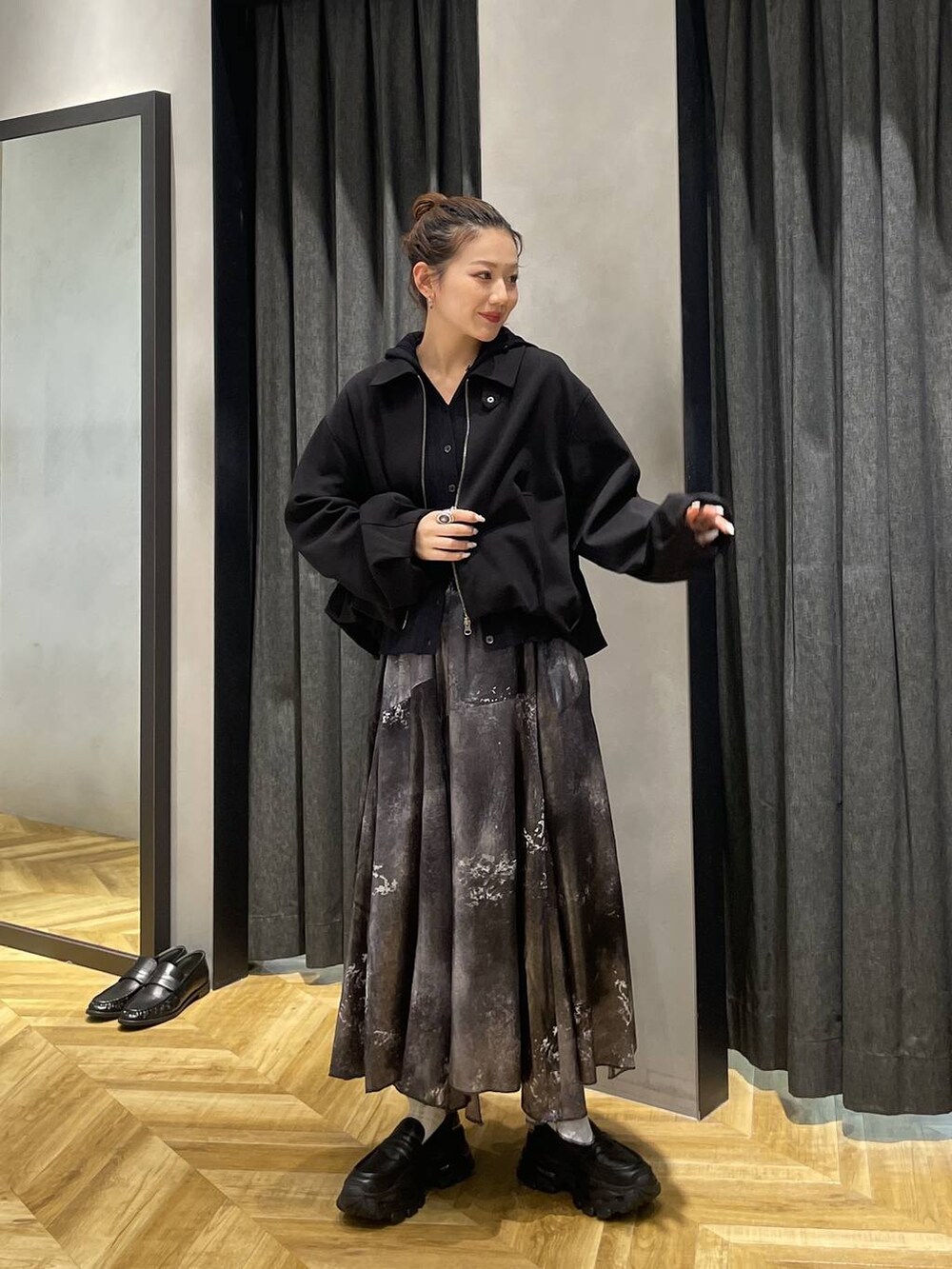 ブラック系のローファー、ブラック系のブルゾン、シルバー系のスカートを着用したレディースの冬コーディネートの8枚目の写真