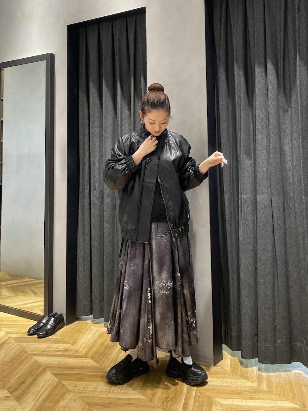 ブラック系のローファー、ブラック系のブルゾン、シルバー系のスカートを着用したレディースの冬コーディネートの6枚目の写真