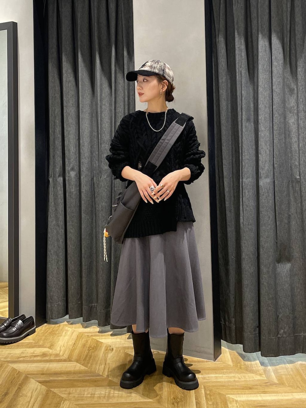 グレー系のショルダーバッグ、ブラック系のブーツ、ブラック系のニット/セーターを着用したレディースの秋コーディネートの8枚目の写真