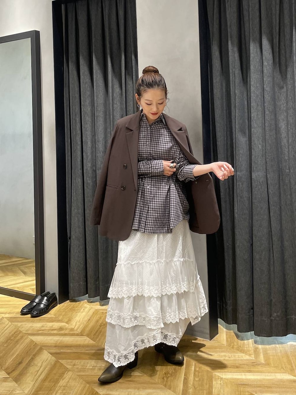 ブラック系のシャツ/ブラウス、ブラウン系のテーラードジャケット、ブラック系のブーツを着用したレディースの冬コーディネートの4枚目の写真