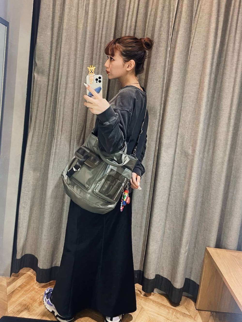 ブラック系のスカート、グリーン系のトートバッグ、ブラック系のスウェットを着用したレディースの冬コーディネートの3枚目の写真