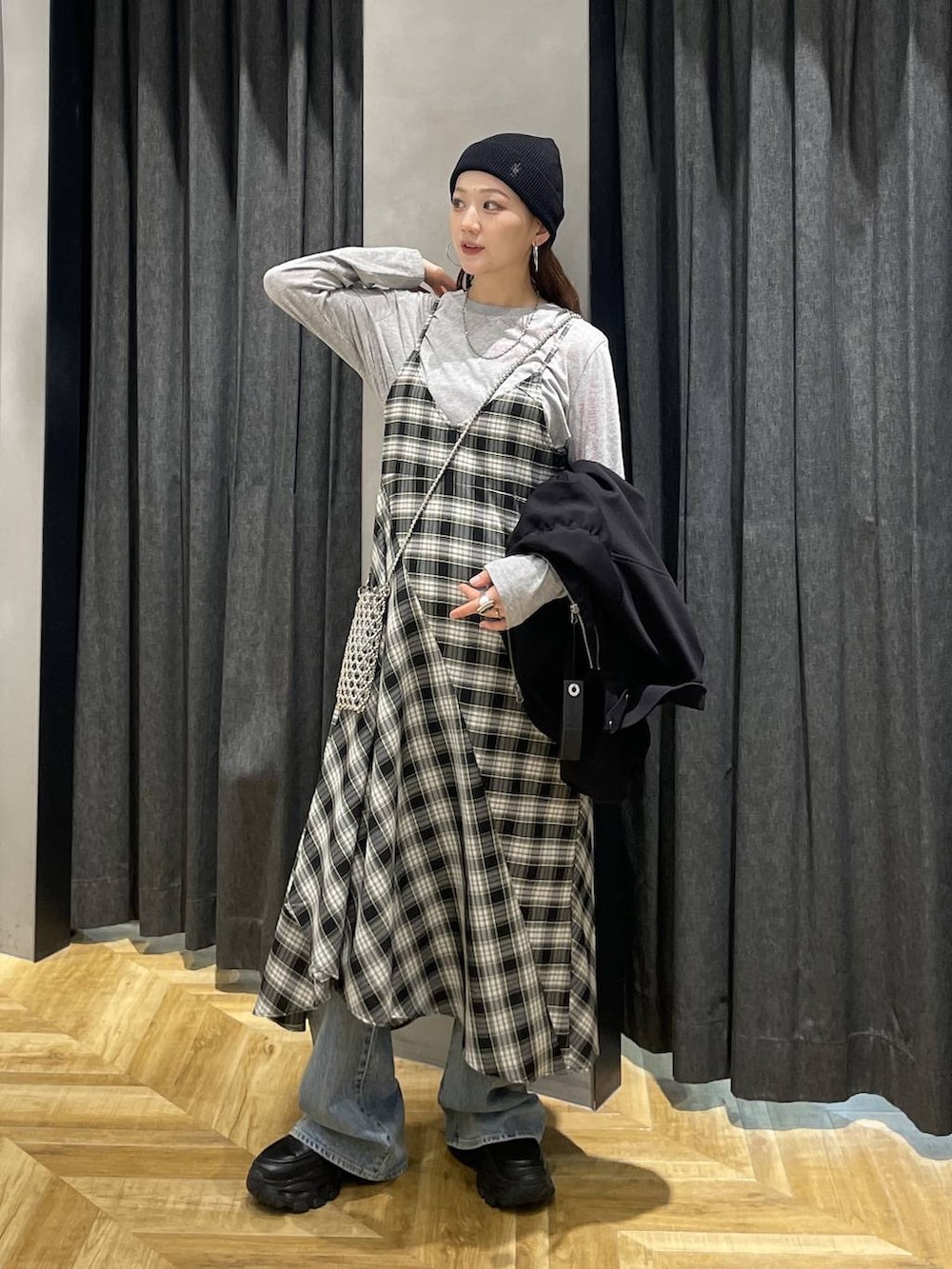 ブラック系のローファー、ブルー系のデニムパンツ、ブラック系のワンピースを着用したレディースの春コーディネートの2枚目の写真