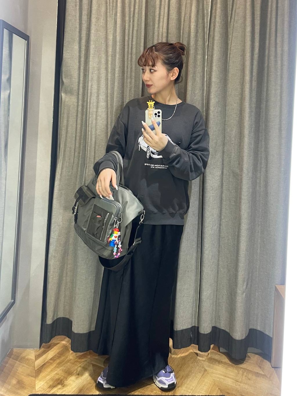 ブラック系のスカート、グリーン系のトートバッグ、ブラック系のスウェットを着用したレディースの冬コーディネートの2枚目の写真