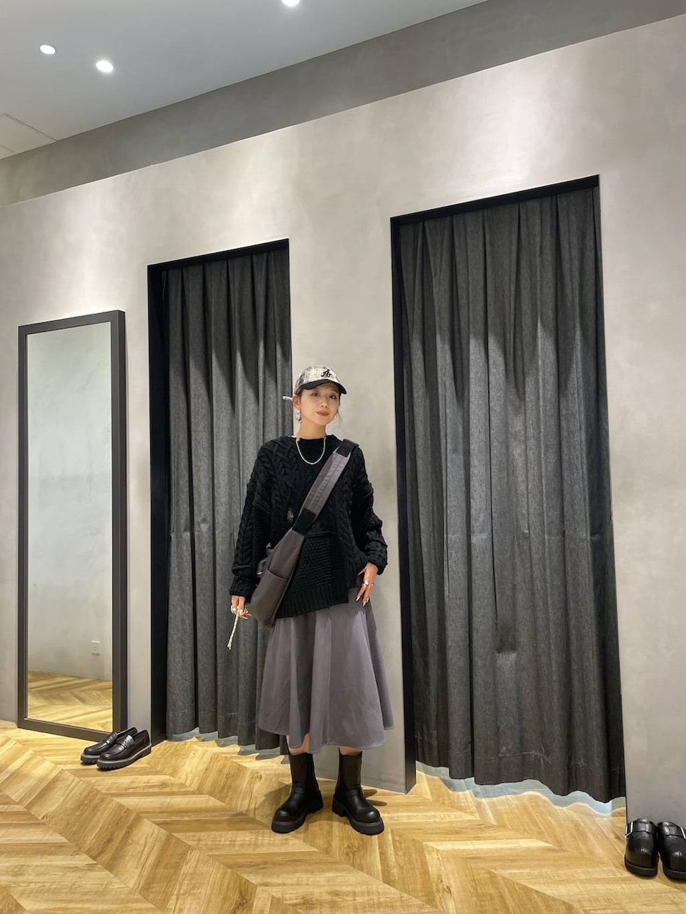 グレー系のショルダーバッグ、ブラック系のブーツ、ブラック系のニット/セーターを着用したレディースの秋コーディネートの9枚目の写真
