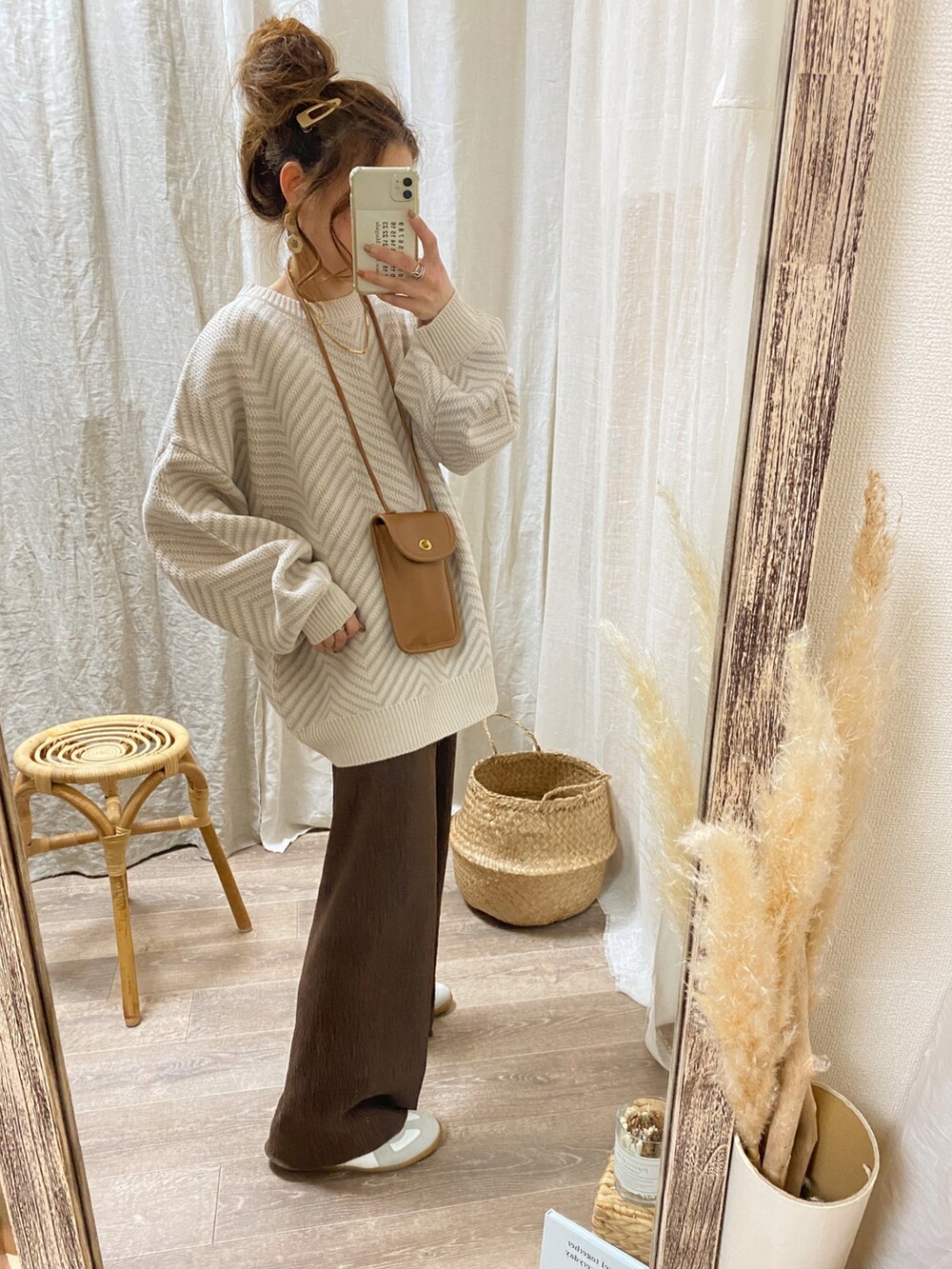 ベージュ系のニット/セーター、イエロー系のショルダーバッグ、ブラウン系のパンツを着用したレディースの冬コーディネートの2枚目の写真