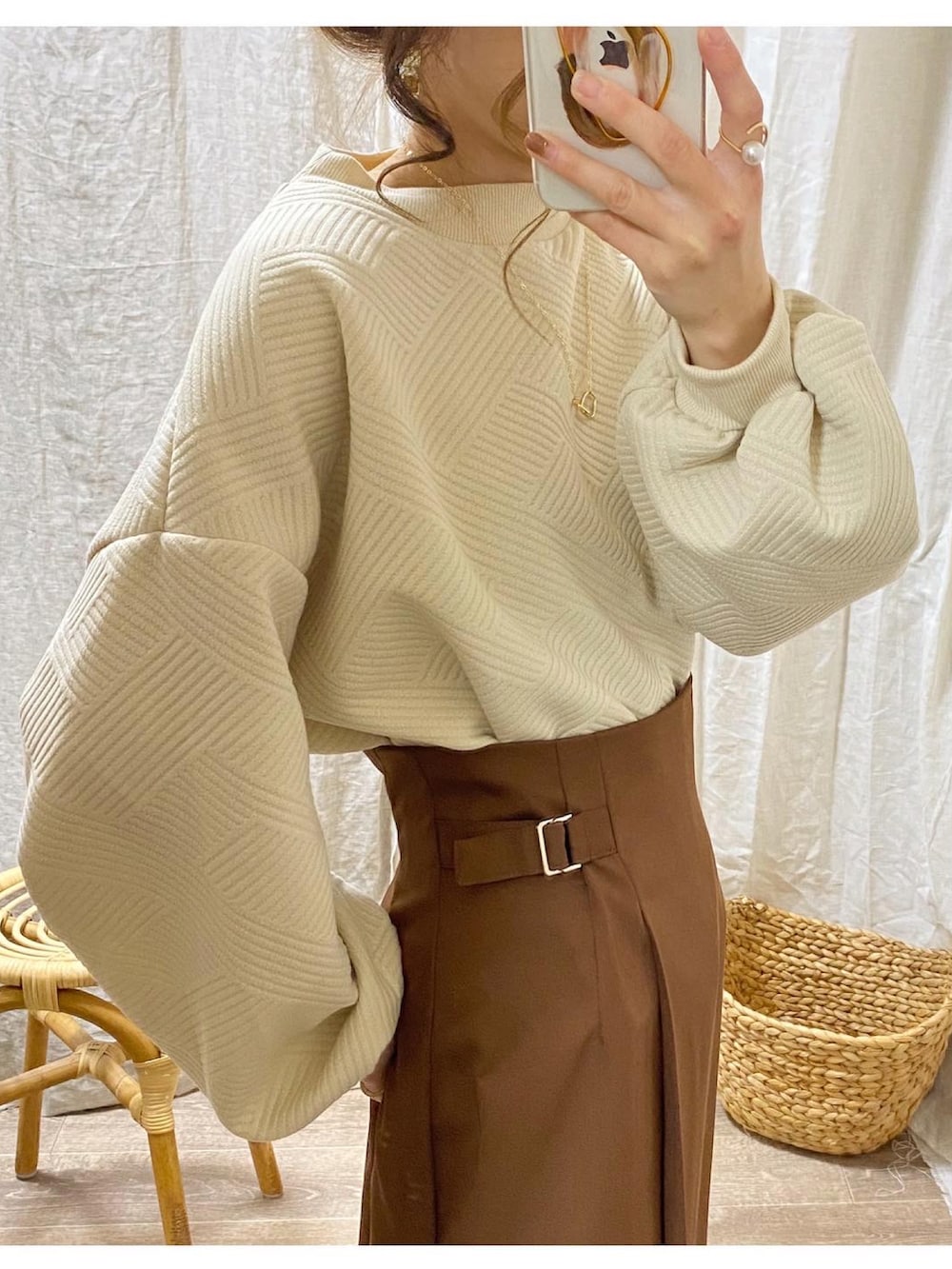 ベージュ系のスウェット、ブラウン系のスカート、ベージュ系のショルダーバッグを着用したレディースの冬コーディネートの2枚目の写真