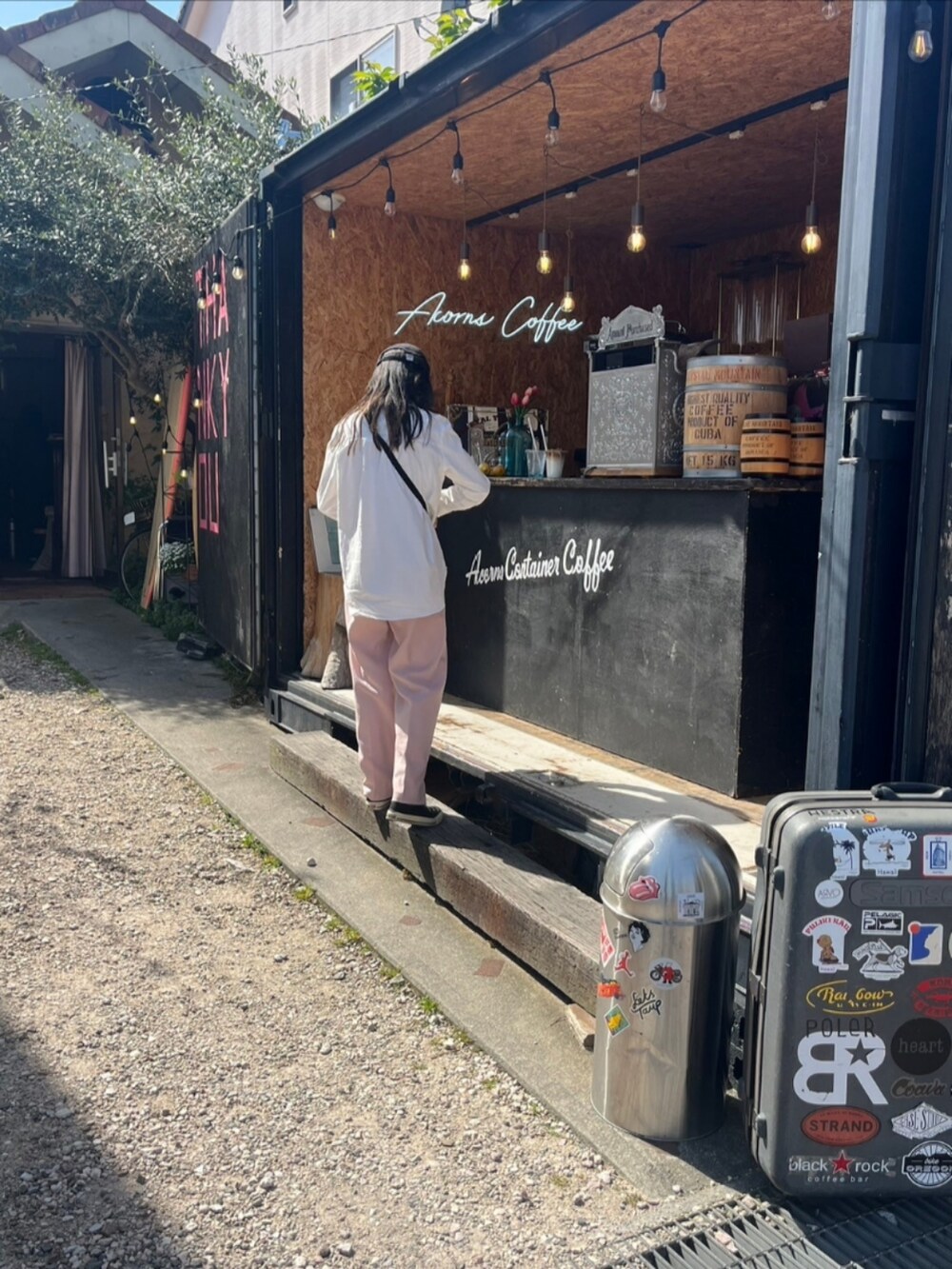 ピンク系のスラックス、ブラック系のスニーカーを着用したレディースの春コーディネートの3枚目の写真