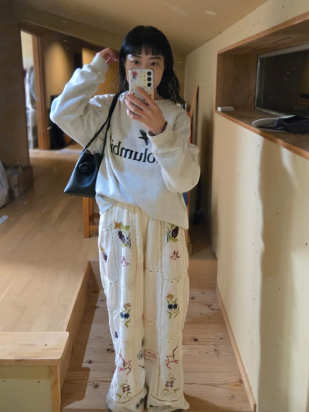 ホワイト系のその他パンツ、ホワイト系のスウェット、ブラック系のハンドバッグを着用したレディースの春コーディネートの2枚目の写真