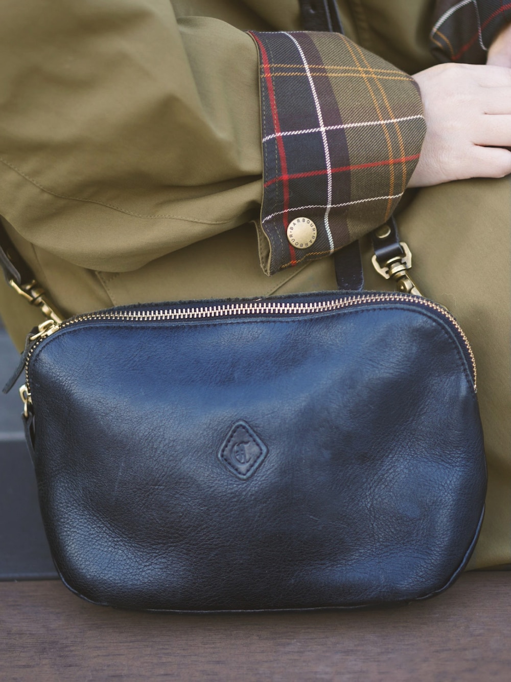 レッド系のニット/セーター、グリーン系のステンカラーコート、グレー系のその他パンツを着用したレディースの冬コーディネートの2枚目の写真