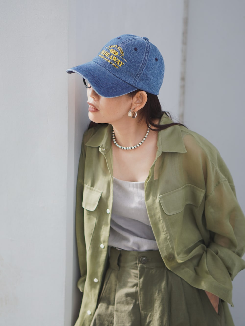 グリーン系のパンツ、グリーン系のシャツ/ブラウス、ブラック系のサンダルを着用したレディースの春コーディネートの2枚目の写真