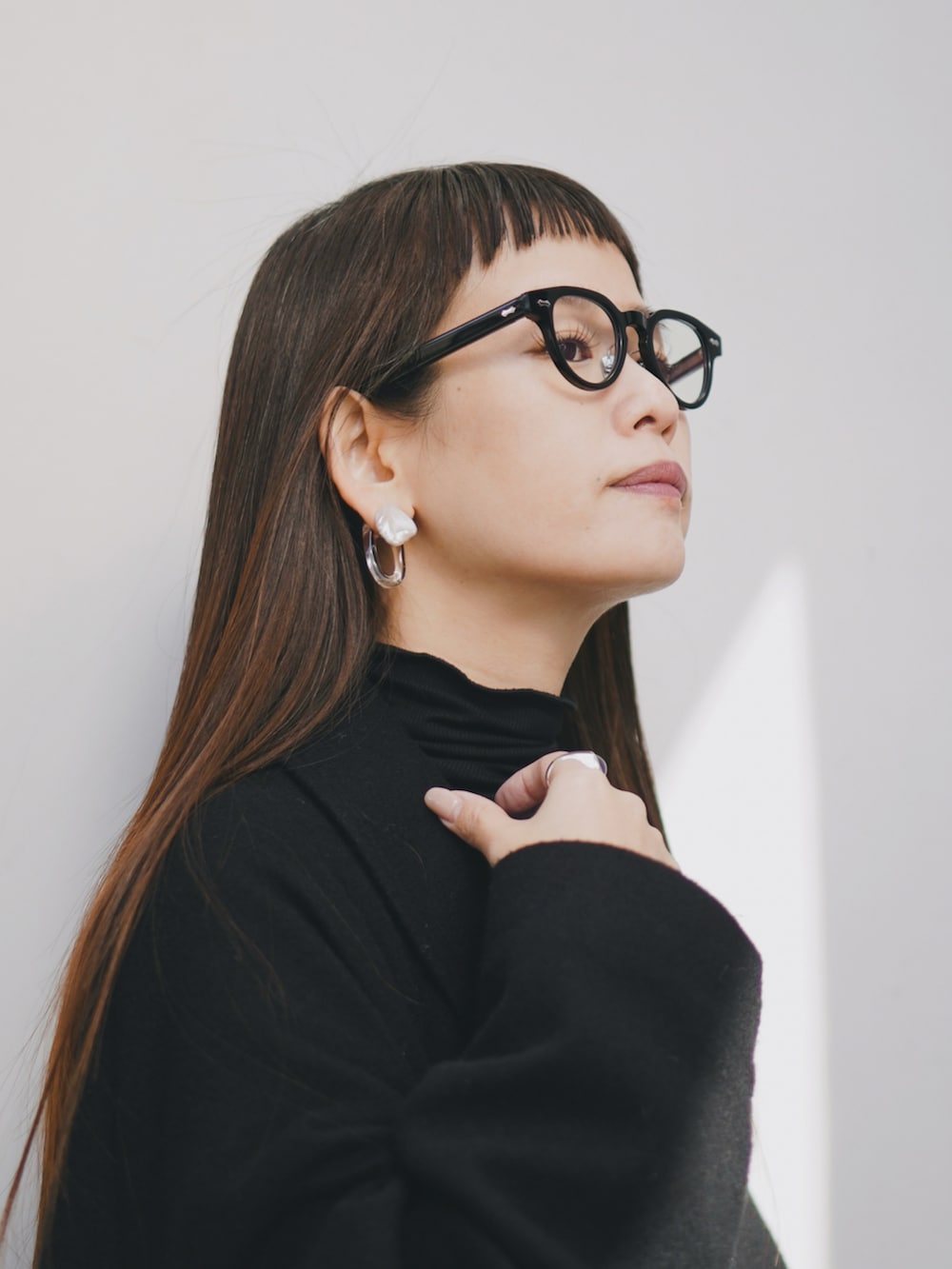 ブラック系のショルダーバッグ、ホワイト系のワンピース、ブラック系のTシャツ/カットソーを着用したレディースの冬コーディネートの2枚目の写真