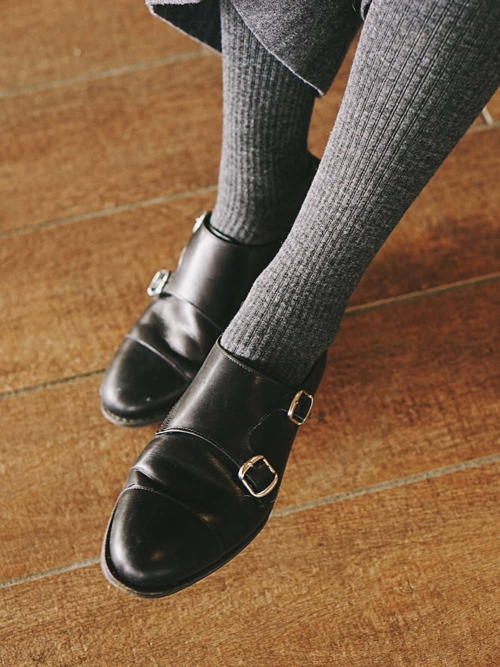 グレー系のその他パンツ、ブラック系のドレスシューズ、ブラウン系のニット/セーターを着用したレディースの冬コーディネートの2枚目の写真