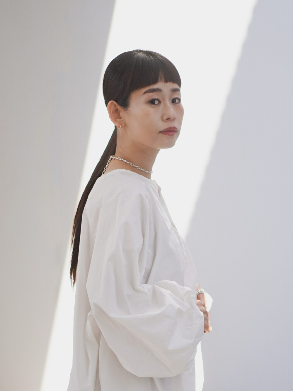 ホワイト系のシャツ/ブラウス、ベージュ系のその他パンツ、シルバー系のバッグを着用したレディースの冬コーディネートの3枚目の写真