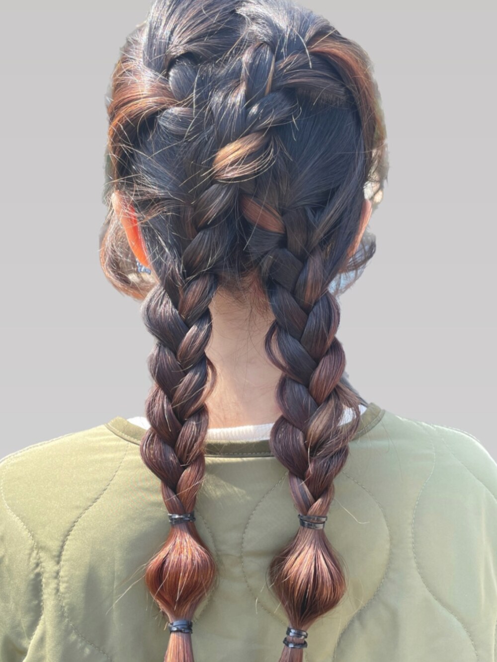 グリーン系のダウンジャケット/コート、ベージュ系のスニーカー、ベージュ系のドラムバッグを着用したレディースの冬コーディネートの2枚目の写真