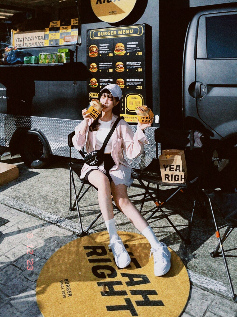 パープル系のスニーカー、ブラック系のボディバッグ/ウエストポーチ、ブラック系のスラックスを着用したレディースの夏コーディネートの2枚目の写真