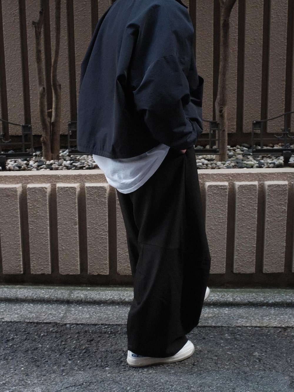 ホワイト系のスニーカーを着用したメンズの秋コーディネートの3枚目の写真