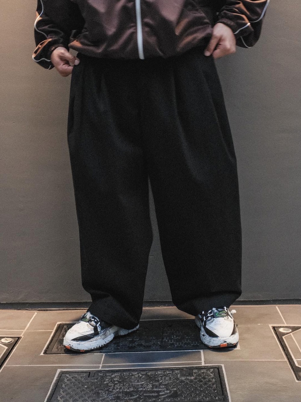 「WILLY CHAVARRIA、communitycentertokyobranch、Maison Margiela、秋ルック紹介するよ、トラックジャケット、ジャージ、チノパン、ブラウン、ブラック、秋のコーデ、ワイドパンツ、ビッグシルエット、白スニーカー、カジュアルコーデ、秋カラー」｜「Maison Margielaのアイテム（スニーカー、ホワイト系）」を使った、UCHIDAさん（メンズ・175cm）の秋コーディネートの2枚目の写真