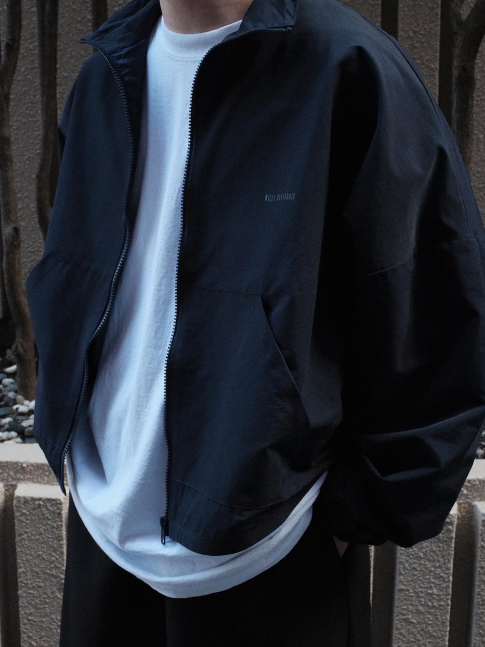 ホワイト系のスニーカーを着用したメンズの秋コーディネートの2枚目の写真