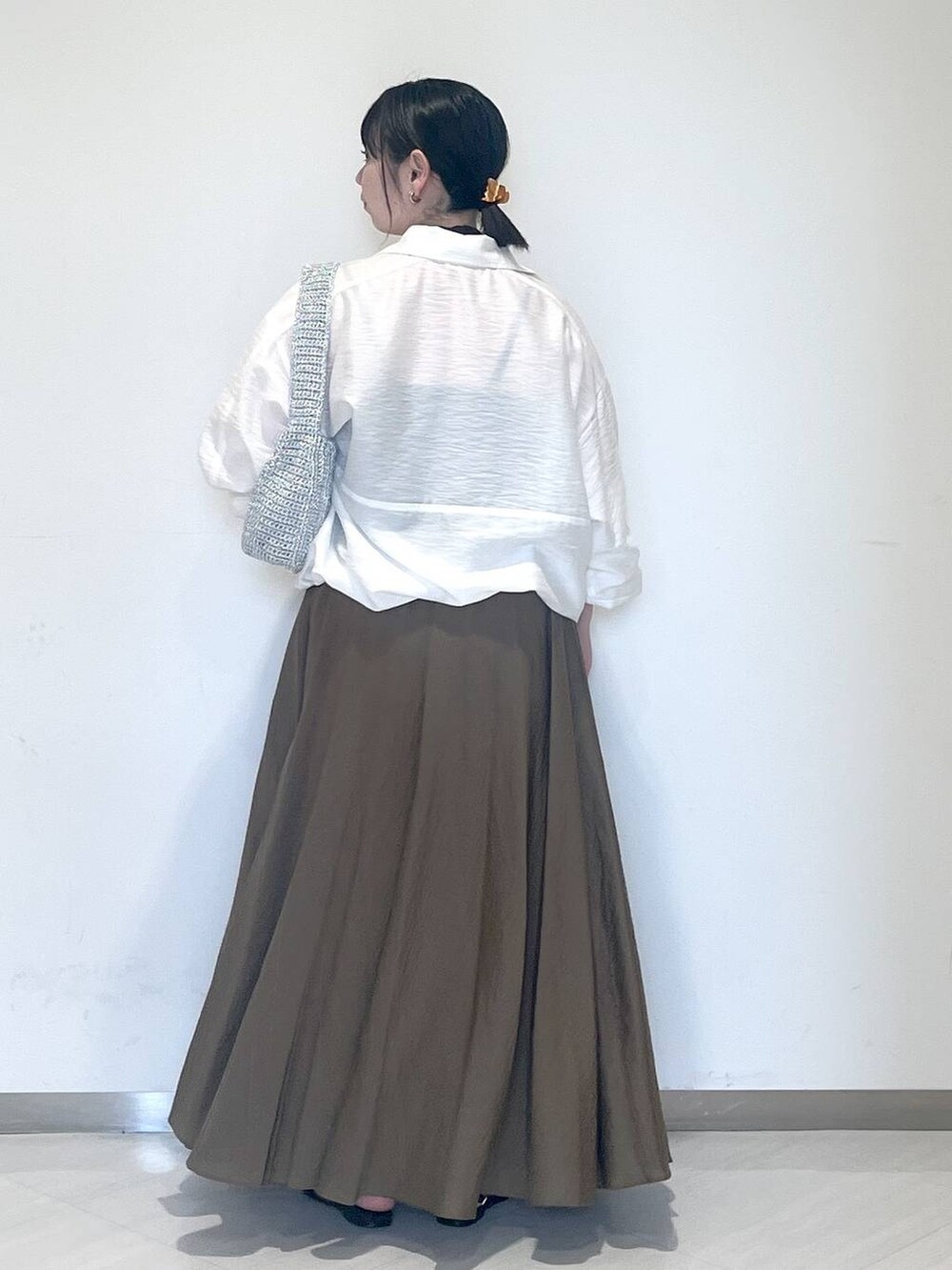 ブラック系のサンダル、シルバー系のハンドバッグを着用したレディースの夏コーディネートの3枚目の写真