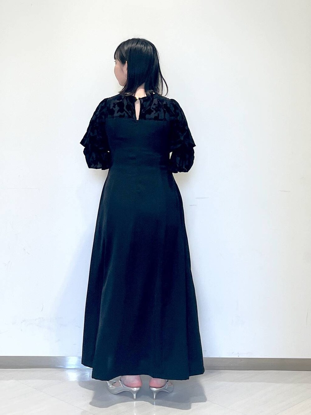 ブラック系のドレス、シルバー系のサンダル、グレー系のショルダーバッグを着用したレディースの春コーディネートの3枚目の写真