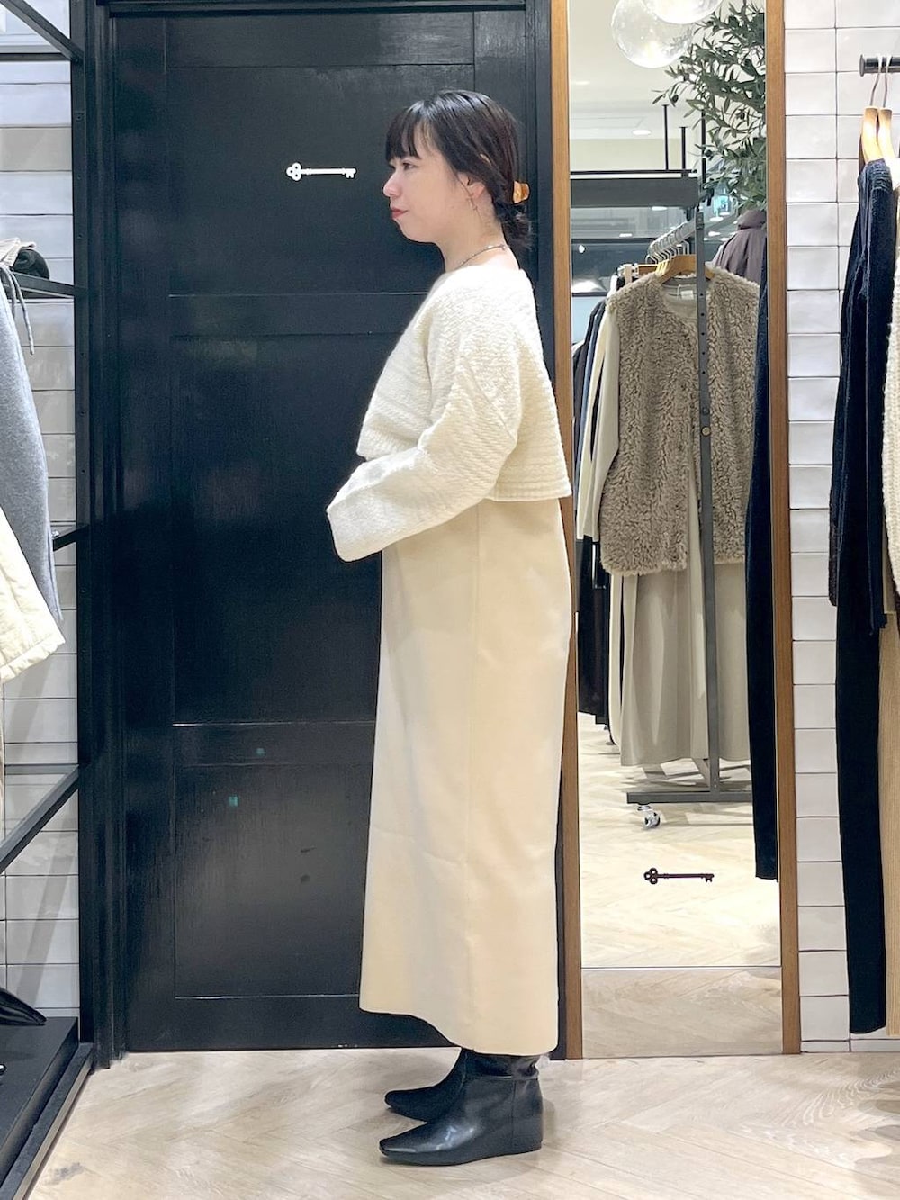 ホワイト系のワンピース、ブラック系のブーツを着用したレディースの秋コーディネートの2枚目の写真