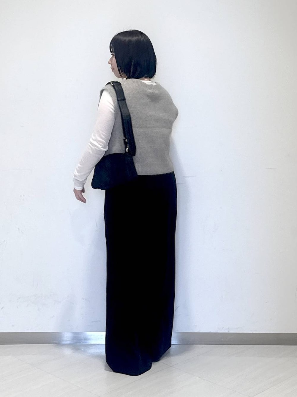 ホワイト系のTシャツ/カットソー、ベージュ系のベスト、ブラック系のスラックスを着用したレディースの秋コーディネートの3枚目の写真