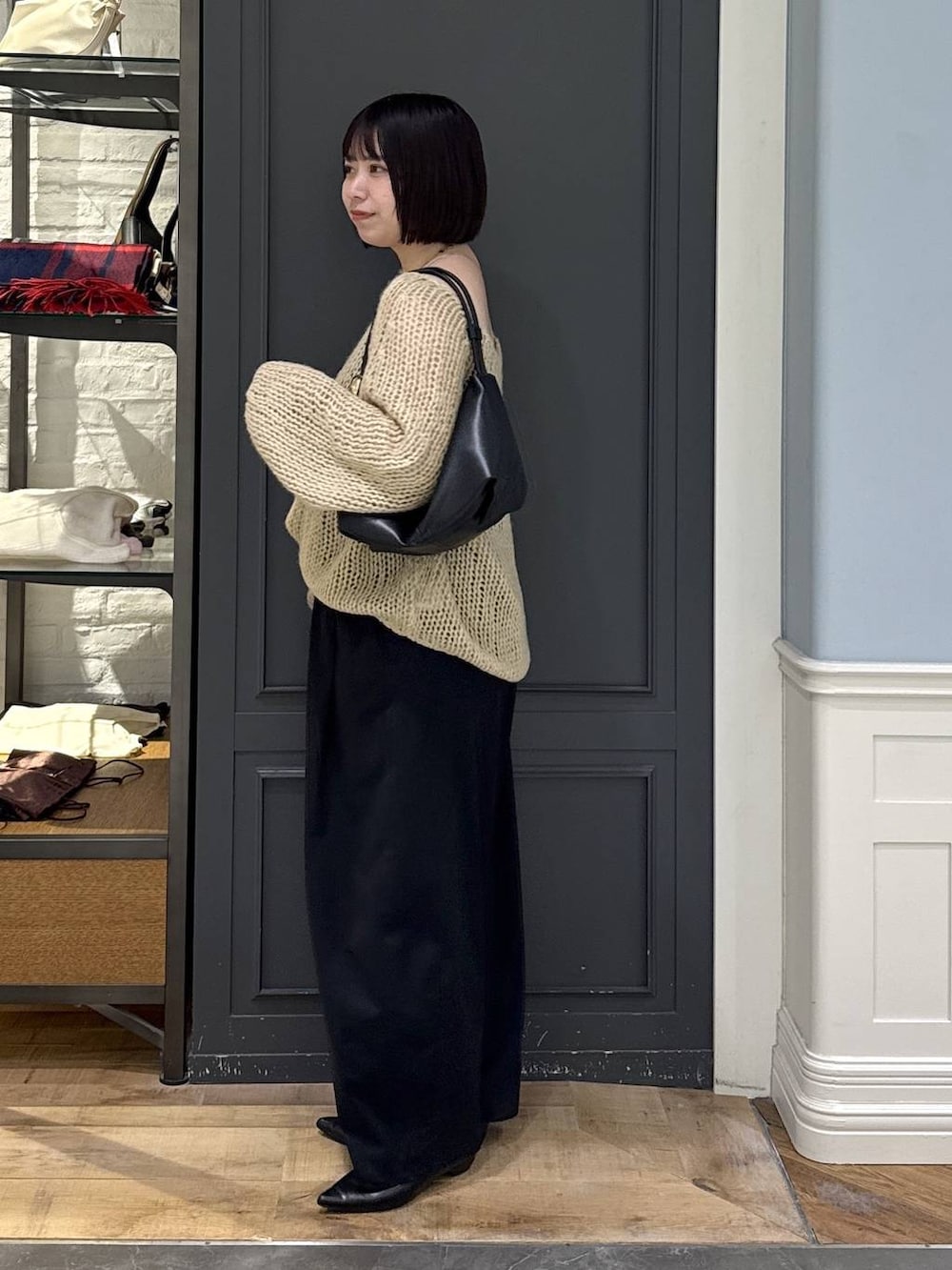 ブラック系のパンプス、ベージュ系のニット/セーター、ブラック系のショルダーバッグを着用したレディースの秋コーディネートの3枚目の写真