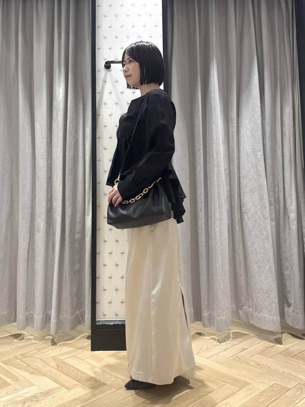 ブラック系のショルダーバッグ、ブラック系のパンプス、ブラック系のシャツ/ブラウスを着用したレディースの春コーディネートの2枚目の写真