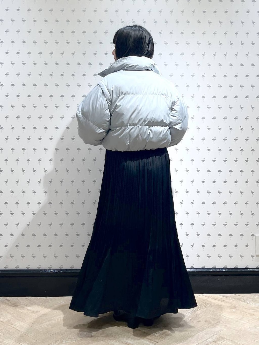 ホワイト系のニット/セーター、ブラック系のブーツ、ブルー系のダウンジャケット/コートを着用したレディースの冬コーディネートの3枚目の写真