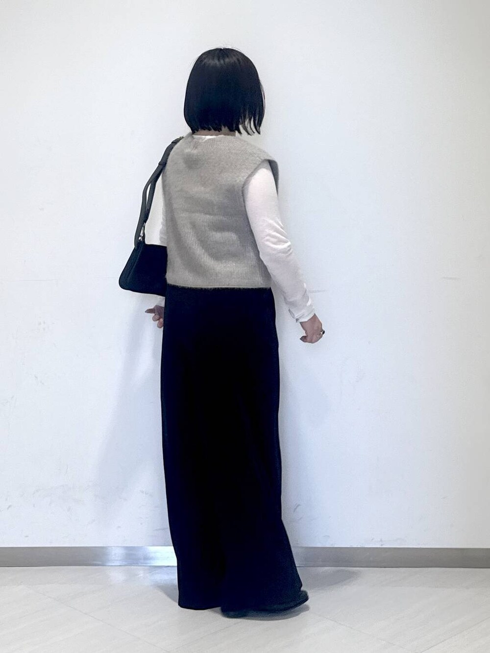 ホワイト系のTシャツ/カットソー、ベージュ系のベスト、ブラック系のスラックスを着用したレディースの秋コーディネートの2枚目の写真