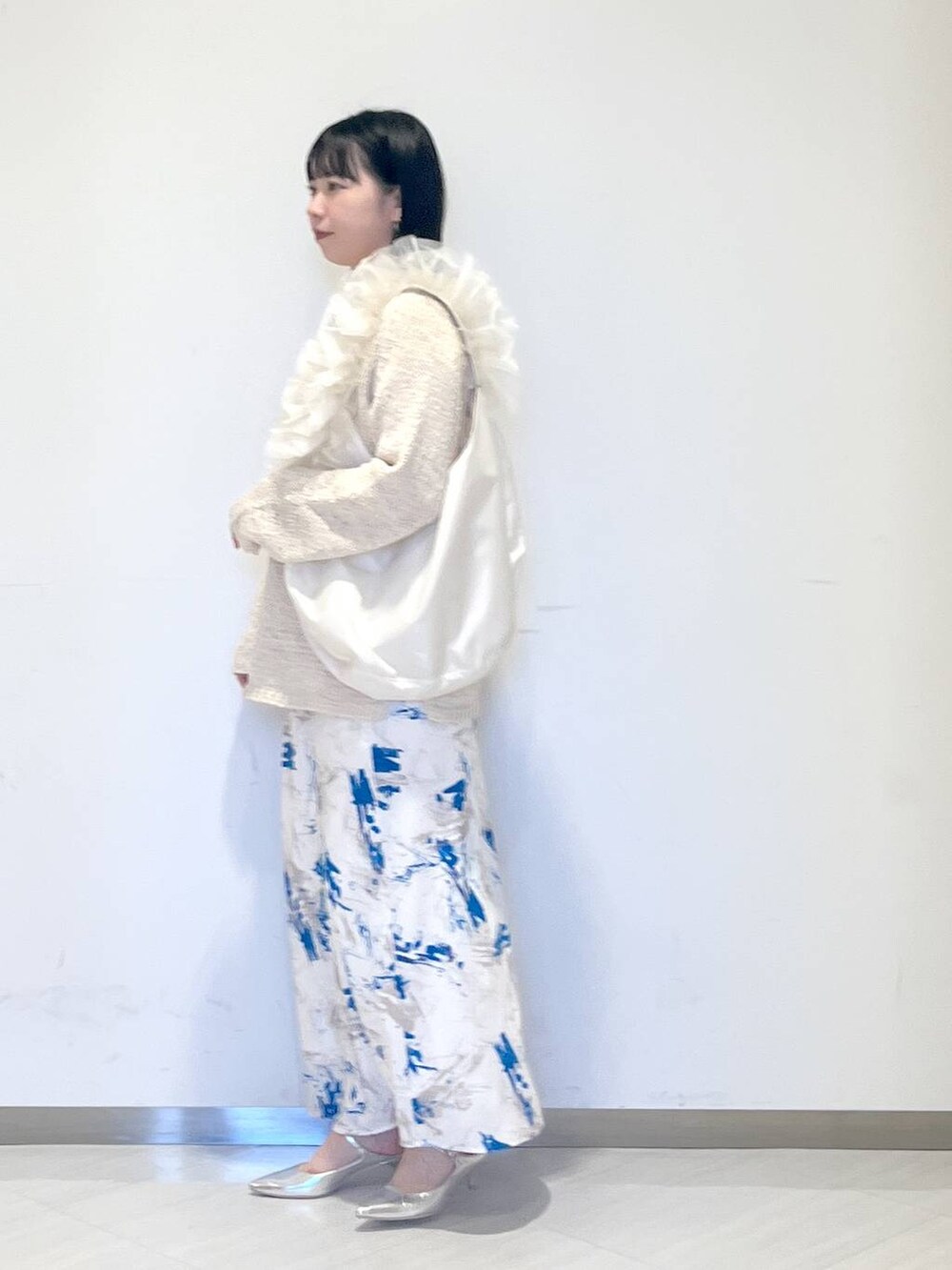 シルバー系のサンダル、ホワイト系のショルダーバッグ、ホワイト系のニット/セーターを着用したレディースの冬コーディネートの2枚目の写真