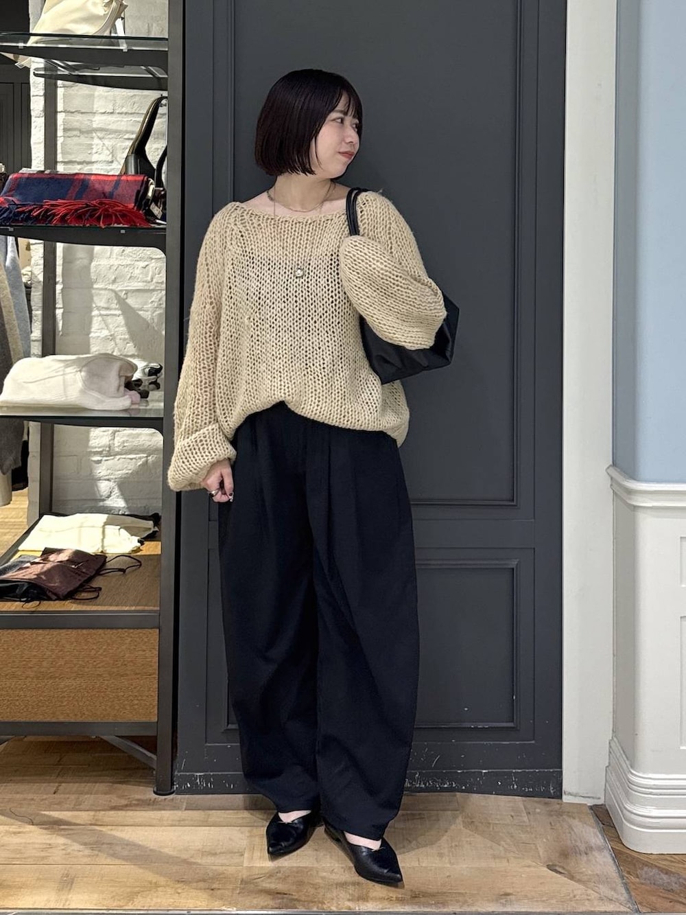 ブラック系のパンプス、ベージュ系のニット/セーター、ブラック系のショルダーバッグを着用したレディースの秋コーディネートの2枚目の写真