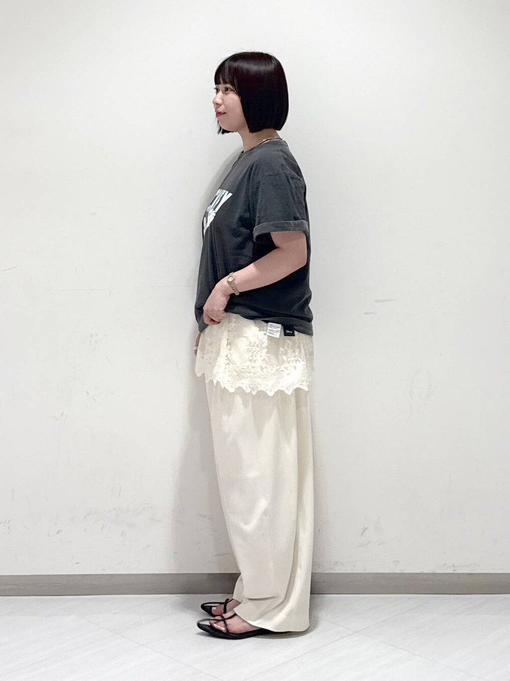 ブラック系のサンダル、ホワイト系のスラックス、グレー系のTシャツ/カットソーを着用したレディースの夏コーディネートの2枚目の写真