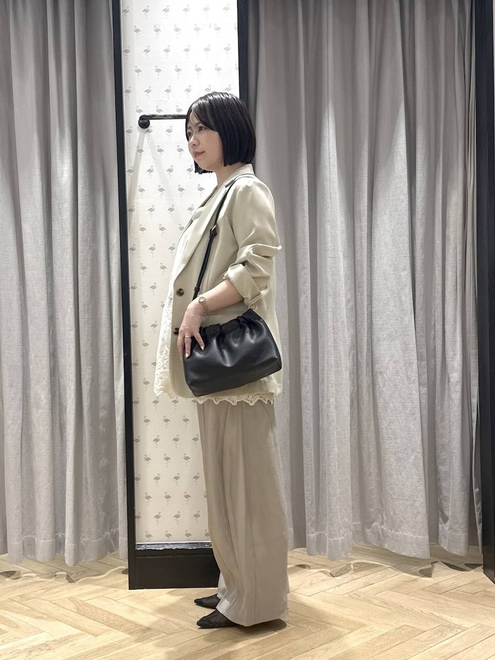 グレー系のその他パンツ、ブラック系のショルダーバッグ、ホワイト系のチュニックを着用したレディースの春コーディネートの2枚目の写真