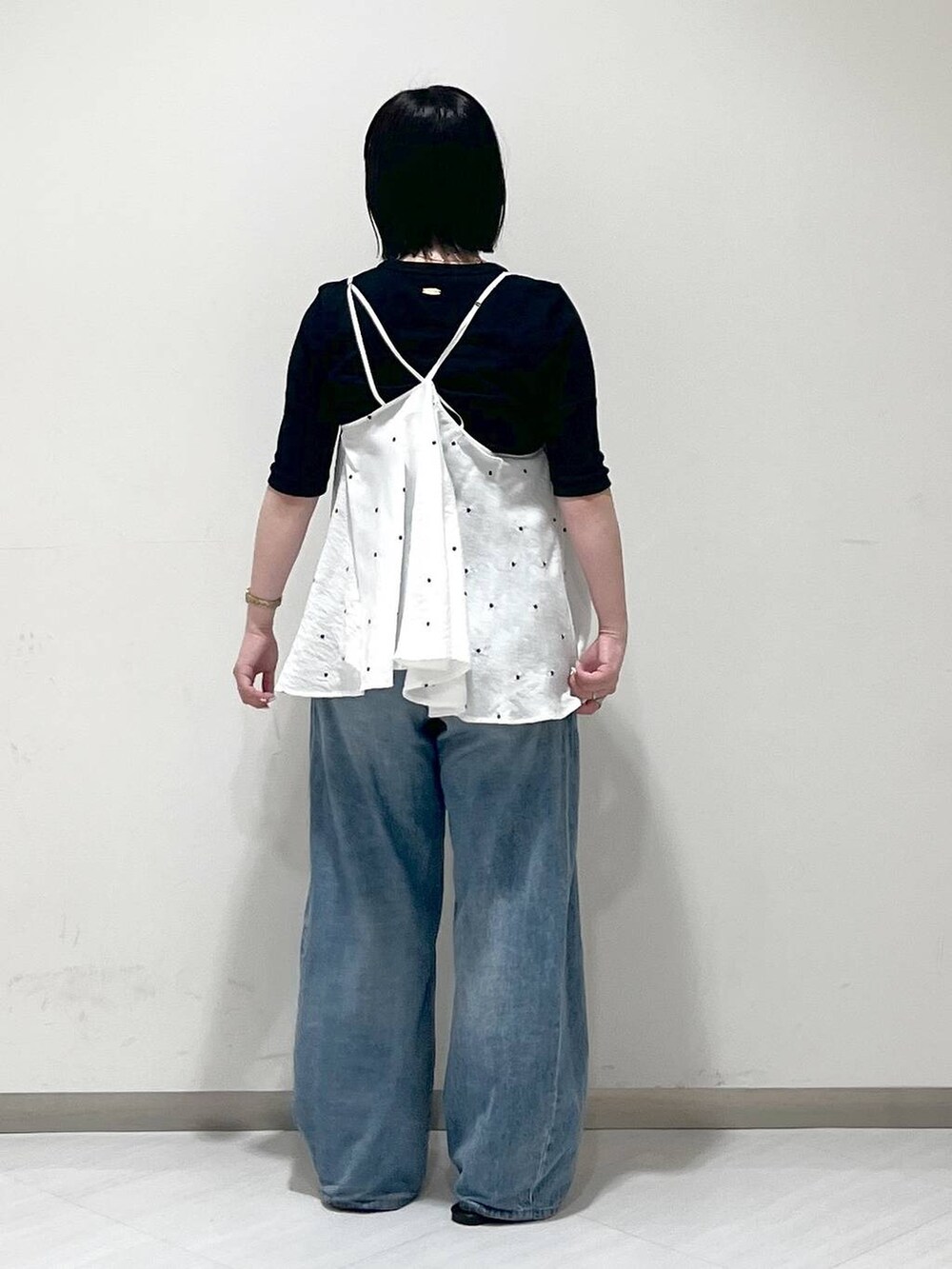 ブルー系のデニムパンツ、ブラック系のサンダル、ブラック系のTシャツ/カットソーを着用したレディースの春コーディネートの3枚目の写真