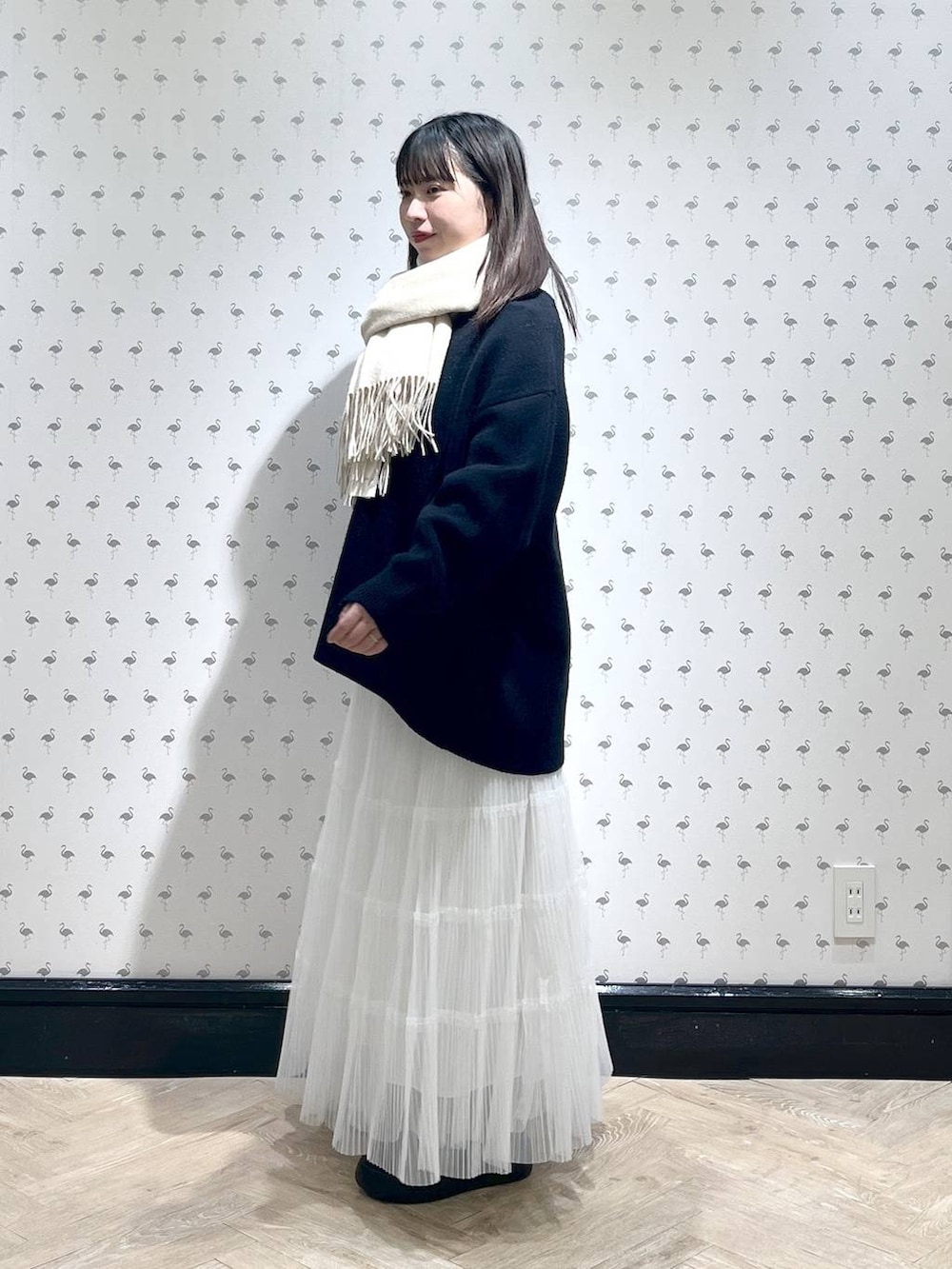ホワイト系のスカート、ブルー系のカーディガン/ボレロ、ベージュ系のストール/ショールを着用したレディースの冬コーディネートの2枚目の写真