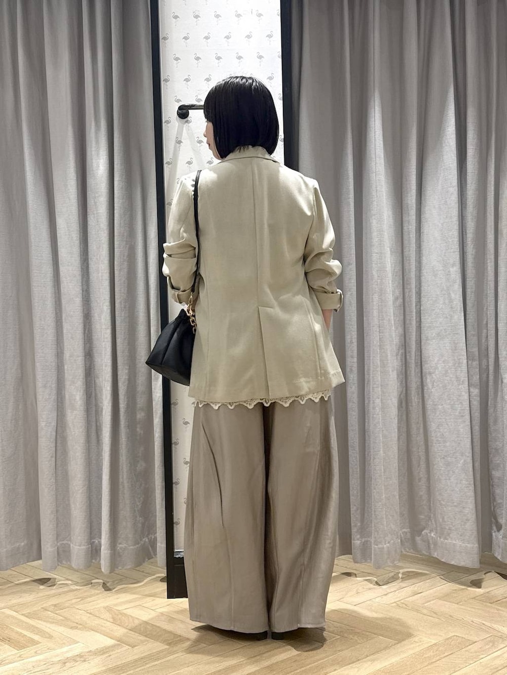 グレー系のその他パンツ、ブラック系のショルダーバッグ、ホワイト系のチュニックを着用したレディースの春コーディネートの3枚目の写真