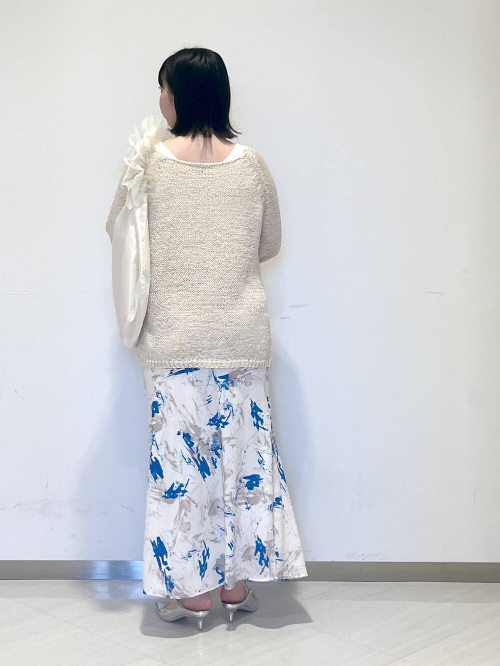 シルバー系のサンダル、ホワイト系のショルダーバッグ、ホワイト系のニット/セーターを着用したレディースの冬コーディネートの3枚目の写真