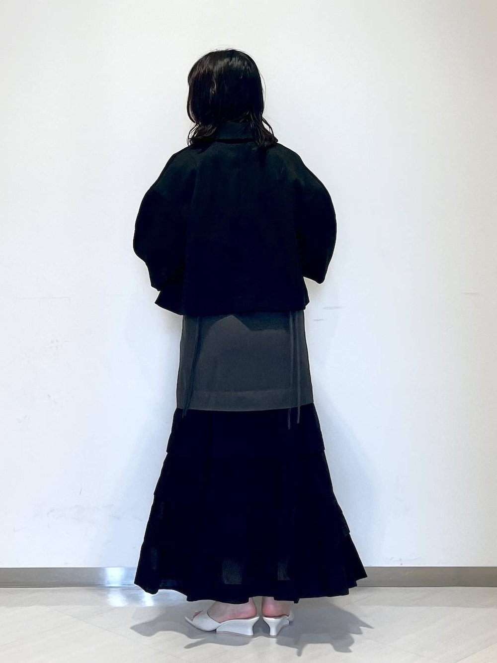 ホワイト系のサンダル、グレー系のワンピース、ブラック系のテーラードジャケットを着用したレディースの夏コーディネートの3枚目の写真