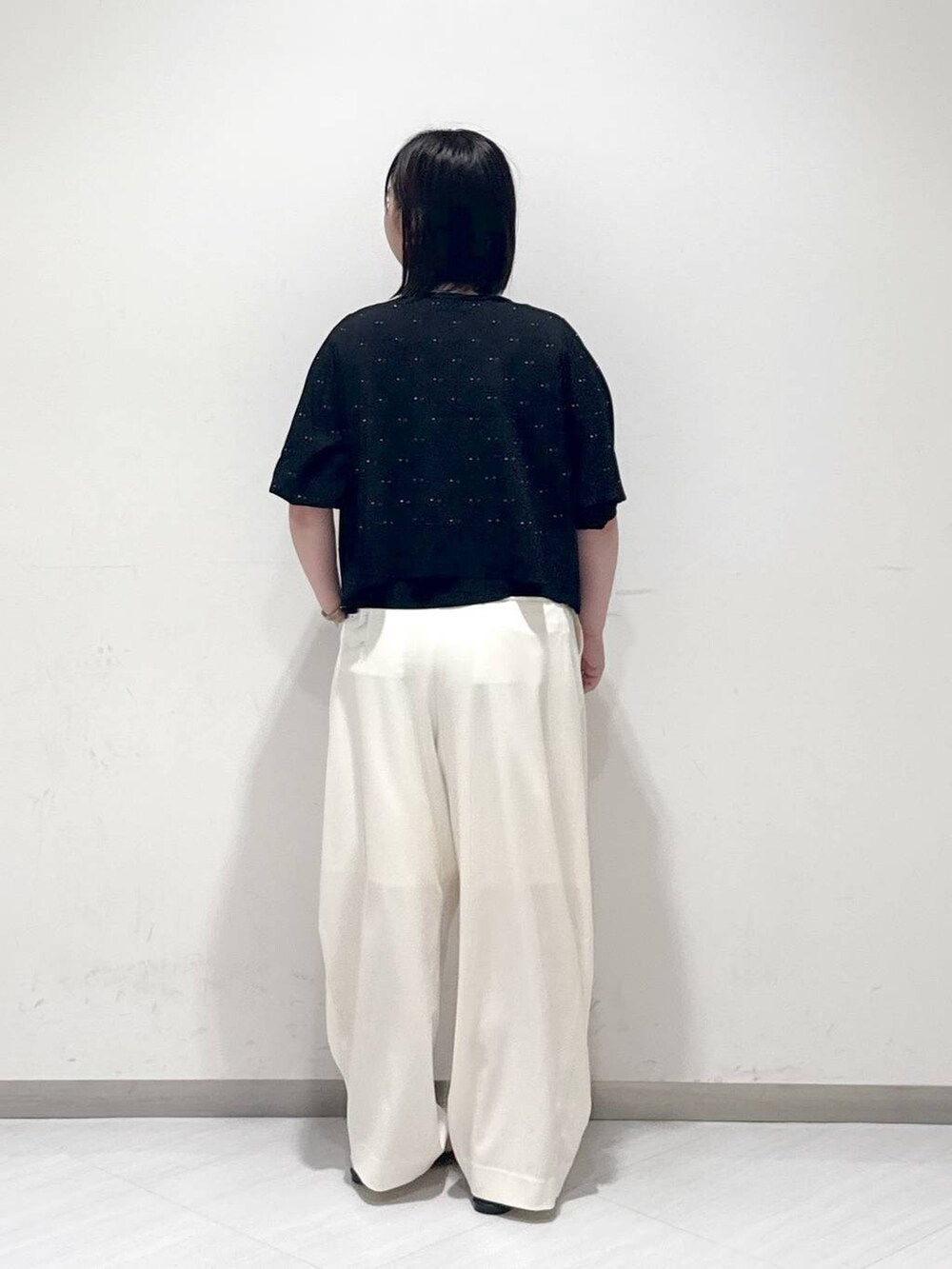 ブラック系のサンダル、ホワイト系のスラックス、ブラック系のタンクトップを着用したレディースの夏コーディネートの3枚目の写真