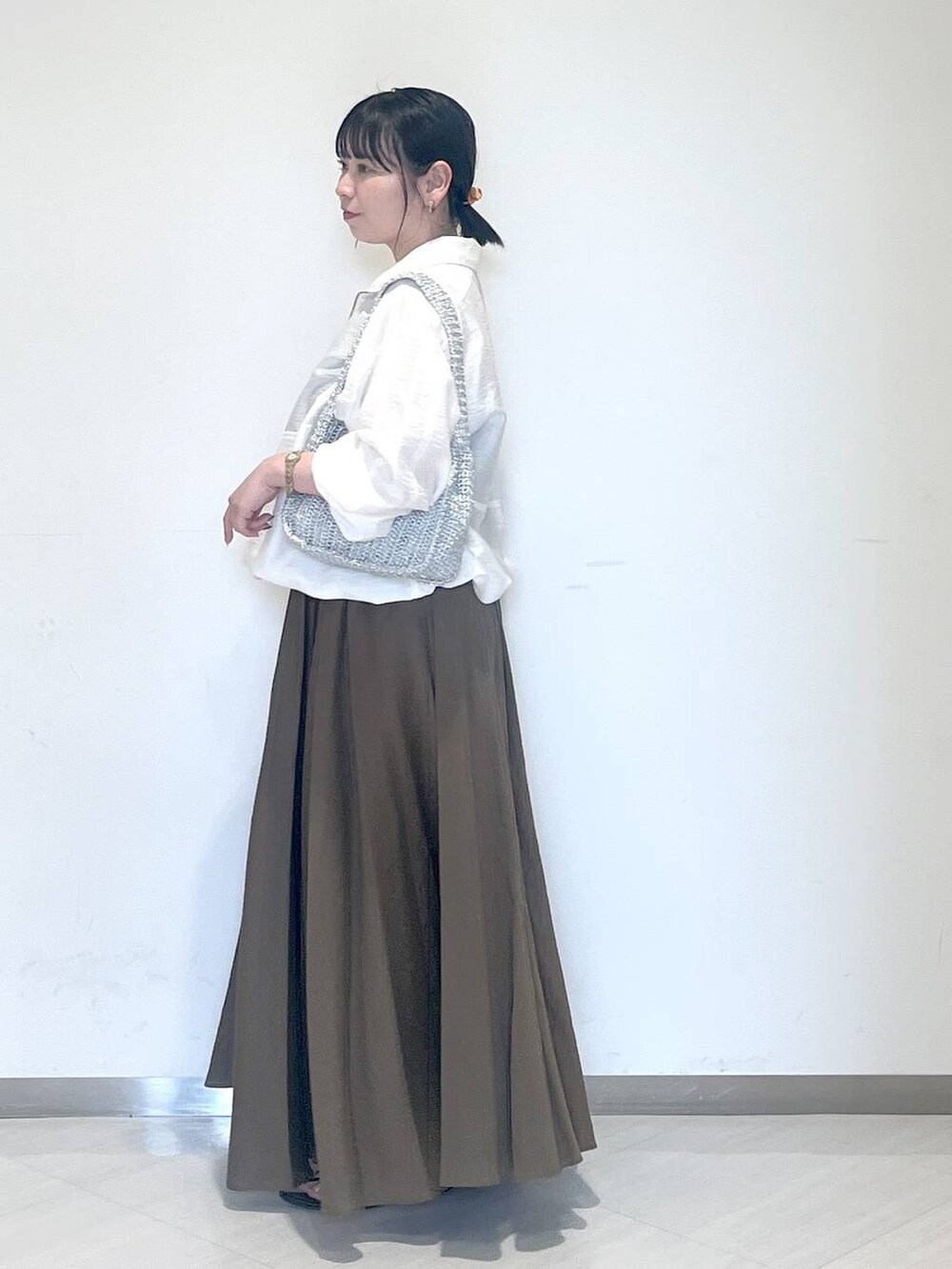 ブラック系のサンダル、シルバー系のハンドバッグを着用したレディースの夏コーディネートの2枚目の写真