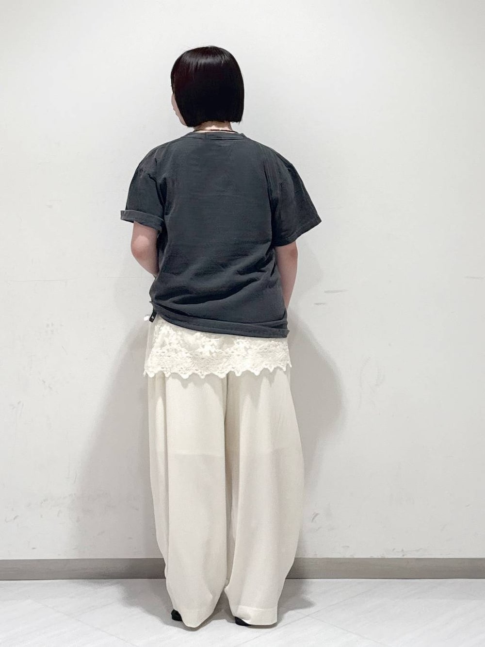 ブラック系のサンダル、ホワイト系のスラックス、グレー系のTシャツ/カットソーを着用したレディースの夏コーディネートの3枚目の写真