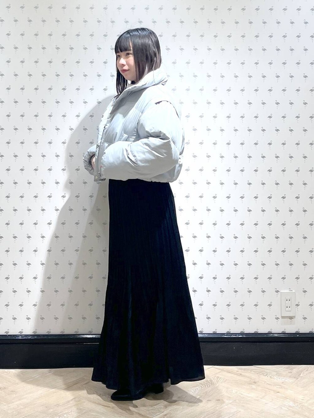 ホワイト系のニット/セーター、ブラック系のブーツ、ブルー系のダウンジャケット/コートを着用したレディースの冬コーディネートの2枚目の写真